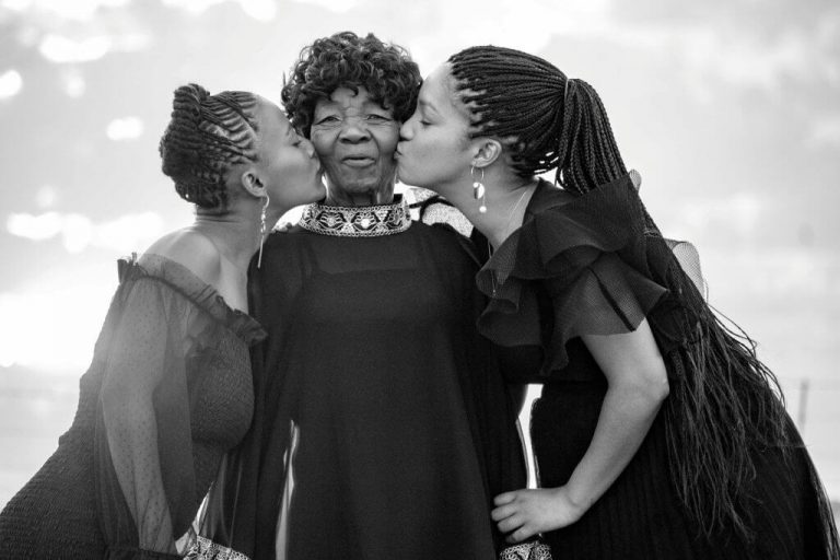Two women kissing their mother on the cheek